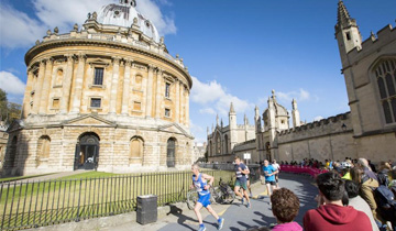 Runners passing an old building in Oxford