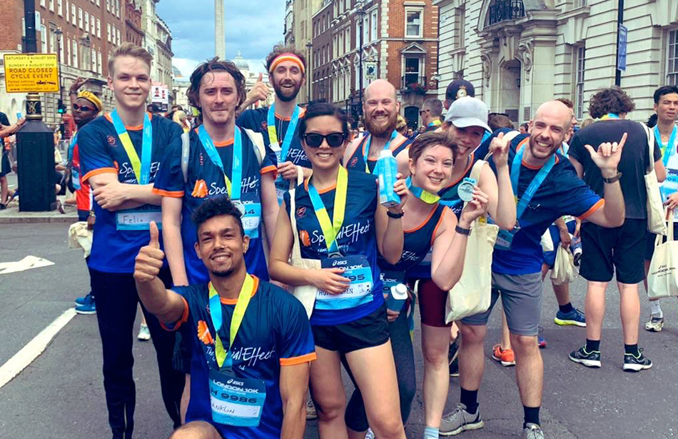 Group of nine runners wearing medals